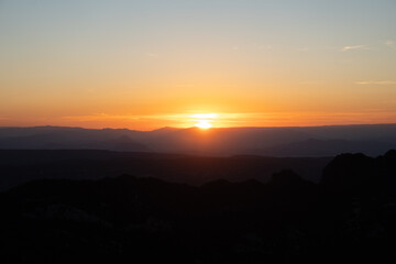 Atardecer entre las montañas con tonos naranjas
