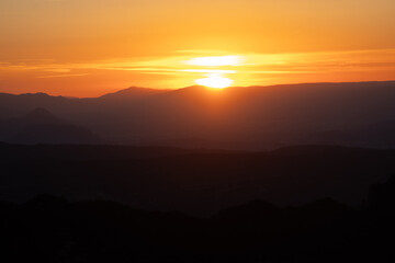 Atardecer entre las montañas con tonos naranjas