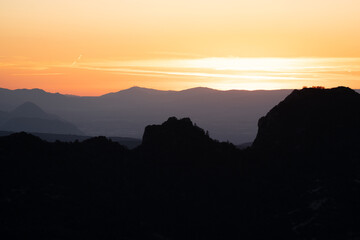 Atardecer entre las montañas con tonos naranjas