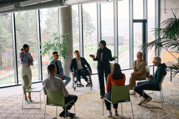Obraz premium Corporate business team meeting with a manager or coach. Group of happy diverse, multiracial people sitting in a circle 