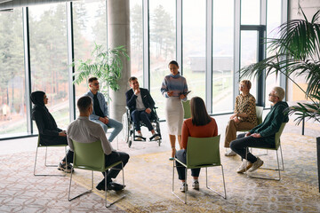 Corporate business team meeting with a manager or coach. Group of happy diverse, multiracial people sitting in a circle 