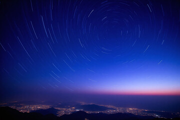Night sky star trails city view blue gradient hues