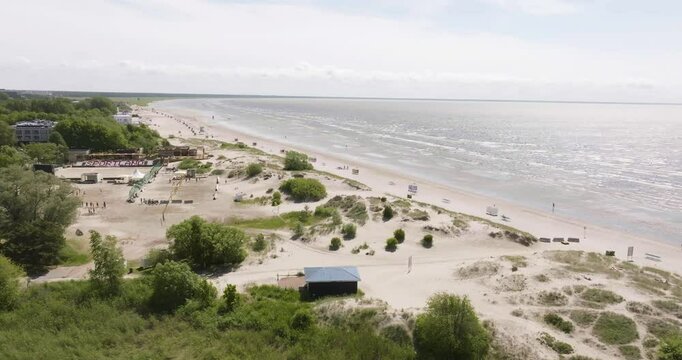 Aerial tracking shot of the quiet Parnu beach, sunny, summer day in Estonia