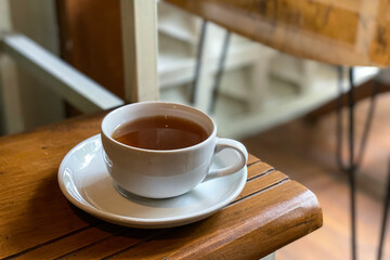 A warm cup of tea on a rustic wooden table, perfect for a cozy breakfast moment.