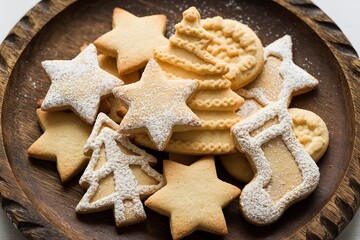 A rustic wooden board with a variety of traditional festive cookies