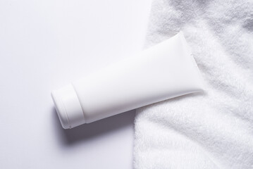 White plastic tube for cosmetic with terry towel, minimalistic concept