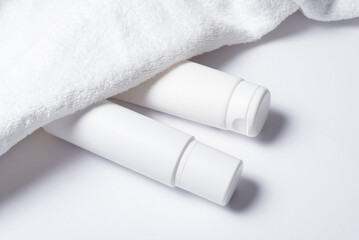 White plastic tube for cosmetic with terry towel, minimalistic concept