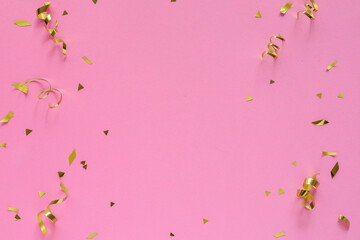 close up top view on rolling and confetti gold color on pink pastel background with copyspace for design as valentine card or mother day or wedding invitation concept