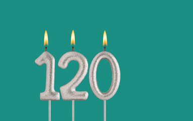 Birthday candle number 120 - Card on a green background.