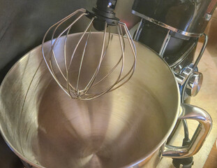 Close-up of a metallic mixing bowl with a whisk attachment, ideal for baking enthusiasts and culinary projects.
