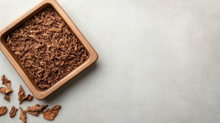 Vintage wooden snuffbox spilling finely chopped tobacco across pristine ceramic surface, empty space available