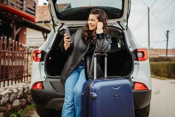 Young caucasian woman packing suitcase in car preparing for travel