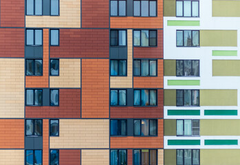 Modern residential complex facade featuring a mix of colors and window designs