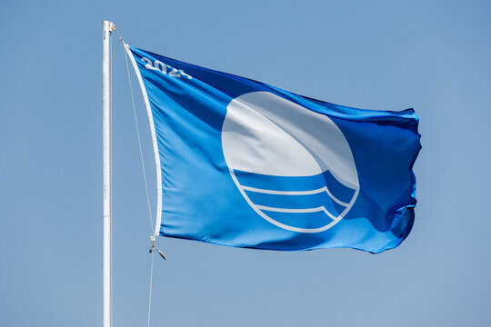 Blue Flag beach. Closeup photo of a flag waving under blue sky