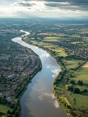 Obraz premium Aerial View of a Serene River Meandering Through Countryside with Lush Green Fields and Residential Areas : Generative AI