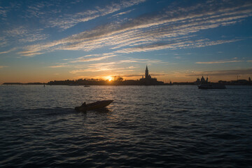 Tramonto a Venezia: gli ultimi raggi di sole colorano il cielo striato di nuvole sul bacino di San...
