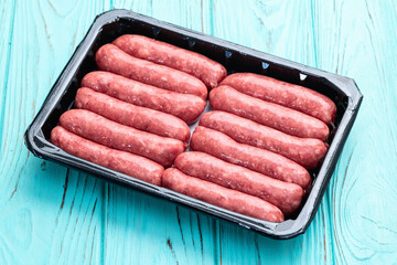 Raw beef sausages with rosemary and tomatoes photography . Top view