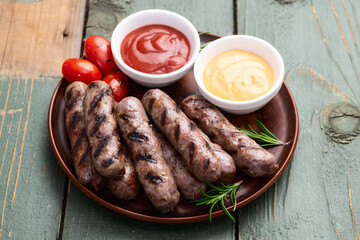Grilled beef sausages with rosemary sauce and tomatoes photography . Top view