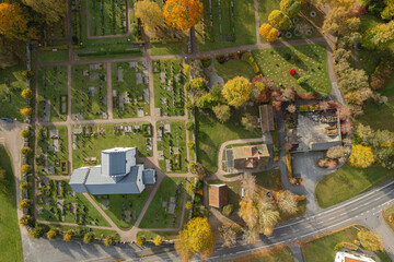 A typical beautiful white old church in Sweden with a cemetery nearby, aerial view, drone shot