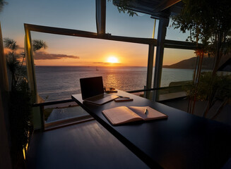 Fototapeta premium Stunning sunset view from a home office. Ideal remote work setting with laptop, notebook, and pen ready for the day.