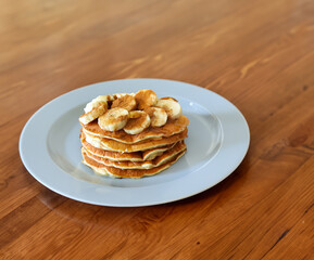 stack of pancakes on a plate with banana and honey 