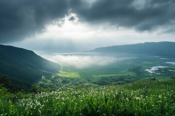 Fototapeta premium Spectacular view of an expansive green valley with sunlight breaking through dramatic clouds, revealing rolling hills, cultivated fields, and a distant mountain range.