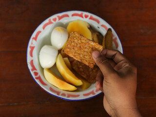 Fried tempeh, boiled banana, boiled egg, and mango slices on a plate. Diet menu, healthy food, breakfast, lunch, dinner. 