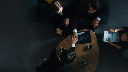 Top down aerial view of team analysis financial graph while female leader join meeting and present stock market investment chart. Smart manager listen presentation while asking question. Directorate.