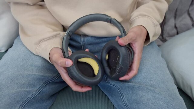 man holding old worn headphones