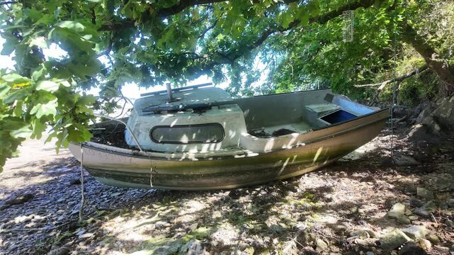 small fiberglass cabin cruiser boat washed up on shore