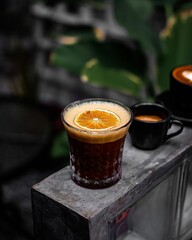 a close-up of a glass of coffee topped with an orange slice