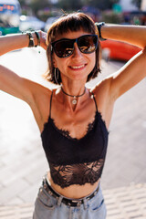 Naklejka premium girl in stylish clothes walking in the city. young cheerful woman smiling and looking at the camera.