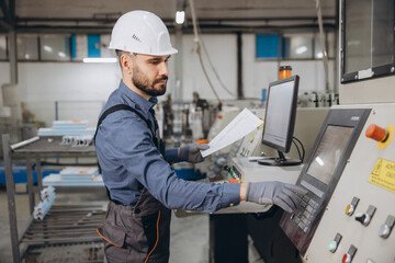 Factory worker operating industrial machinery for aluminum and PVC windows and doors production