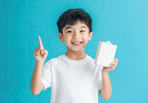 asian boy holding milk carton and showing open mouth with one finger up isolated on blue background - Powered by Adobe