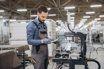 Factory worker checking notes during aluminum and pvc windows and doors production