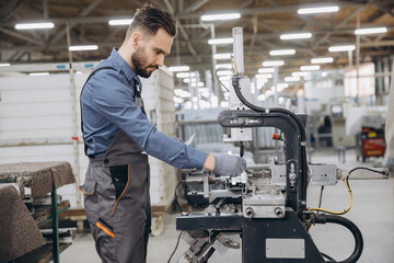 Factory worker operating machinery producing aluminum and pvc windows and doors