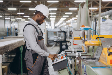 Factory worker operating machinery producing aluminum and pvc windows and doors