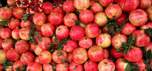 Fresh red pomegranates displayed on the shelves in traditional market stalls, pomegranates fruit background