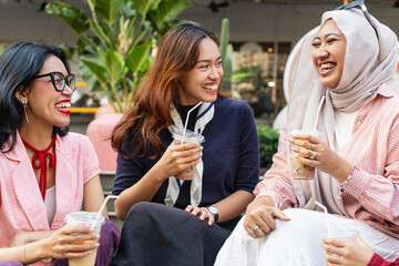 Happy Asian girls having fun enjoying drinks together. Modern and diverse female friends