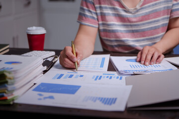 A man sits at his desk at home at night, working on his laptop. He views charts, checks documents, and analyzes financial data, focusing on investments, stock trading, and shareholder rights