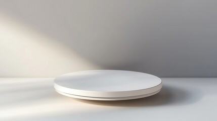 a white, round, empty podium platform standing on the floor against a grey background, in a minimalist style with a soft shadow
