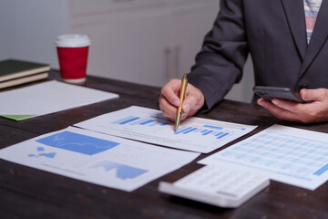 A man sits at his desk at home at night, working on his laptop. He views charts, checks documents, and analyzes financial data, focusing on investments, stock trading, and shareholder rights