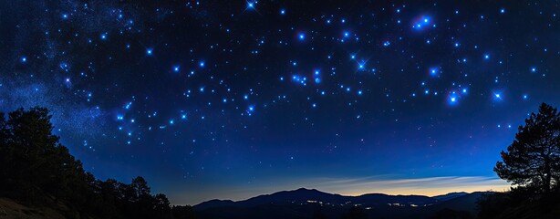 A starry night sky with a few trees in the background