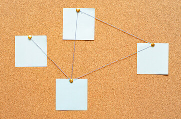 Blank paper notes are pinned to a cork board. The concept of detective investigation or training. Copy space.