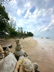 A large pile of various rocks situated on a beach by the ocean