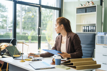 A young female lawyer sits at her desk in the office, providing online legal advice professionally....