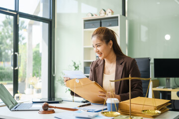 A young female lawyer sits at her desk in the office, providing online legal advice professionally....