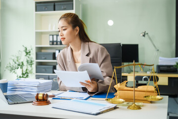 A young female lawyer sits at her desk in the office, providing online legal advice professionally....