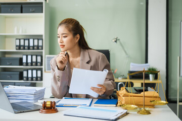 A young female lawyer sits at her desk in the office, providing online legal advice professionally....