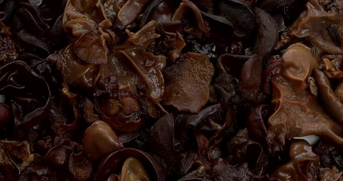 Whole dried and hydrated mun mushrooms. Background texture. Table spin.